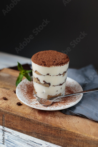 Italian dessert tiramisu closeup on wooden table, mint