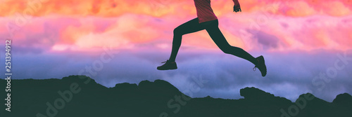 Canvas Print Running legs silhouette of athlete runner woman trail running on mountain rocks against pink sunset sky background