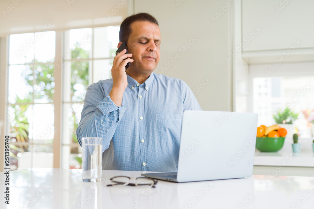 Middle age man working with laptop and using smartphone Middle age man working with laptop and using smartphone