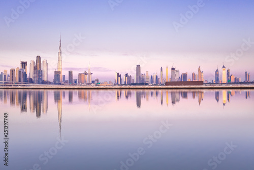 Beautiful colorful purple and pink sunrise lighting up the skyline and the reflection of Dubai Downtown. Dubai  United Arab Emirates.
