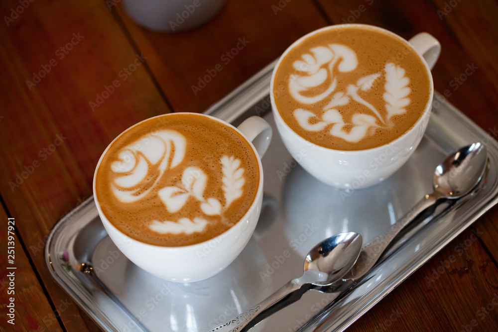 Two white cups of cappuccino with rose pattern. Latte art coffee Stock  Photo | Adobe Stock