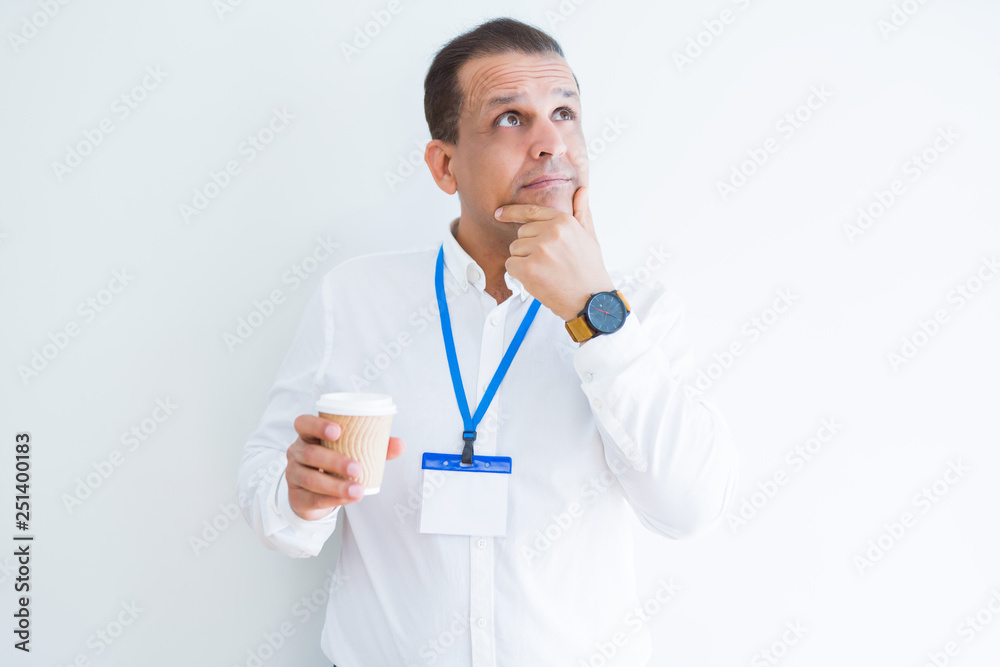 Middle age business man wearing ID card and drinking coffeeover white background serious face thinking about question, very confused idea Middle age business man wearing ID card and drinking coffeeover white background serious face thinking about question, very confused idea