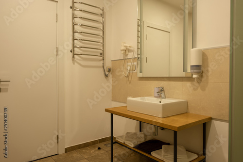 bathroom interior with sink, towels, mirror and hair dryer © LIGHTFIELD STUDIOS