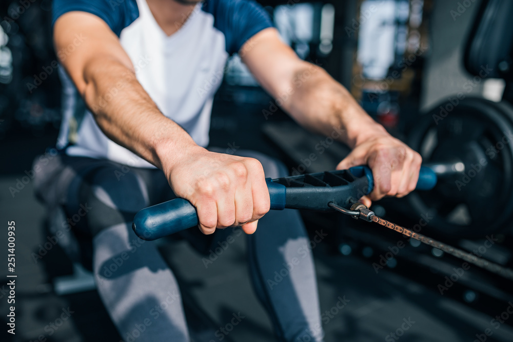 Close-up image of man working out in the gym, on the rowing machine. Close-up image of man working out in the gym, on the rowing machine.