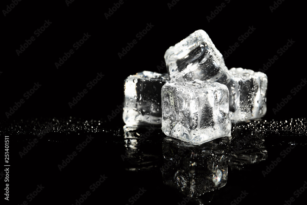 Pile of crystal clear ice cubes on black background. Space for text