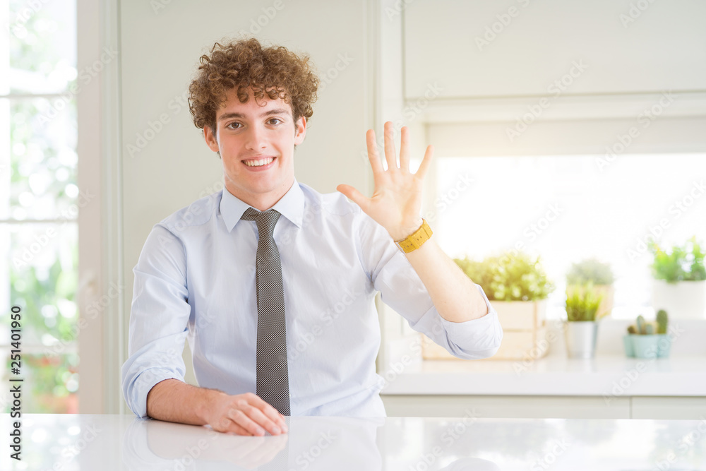 Young business man wearing a tie showing and pointing up with fingers number five while smiling confident and happy.