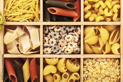 The top view on different pasta in a wooden box. Food background