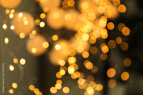 Blurred view of gold lights on dark background. Bokeh effect © New Africa