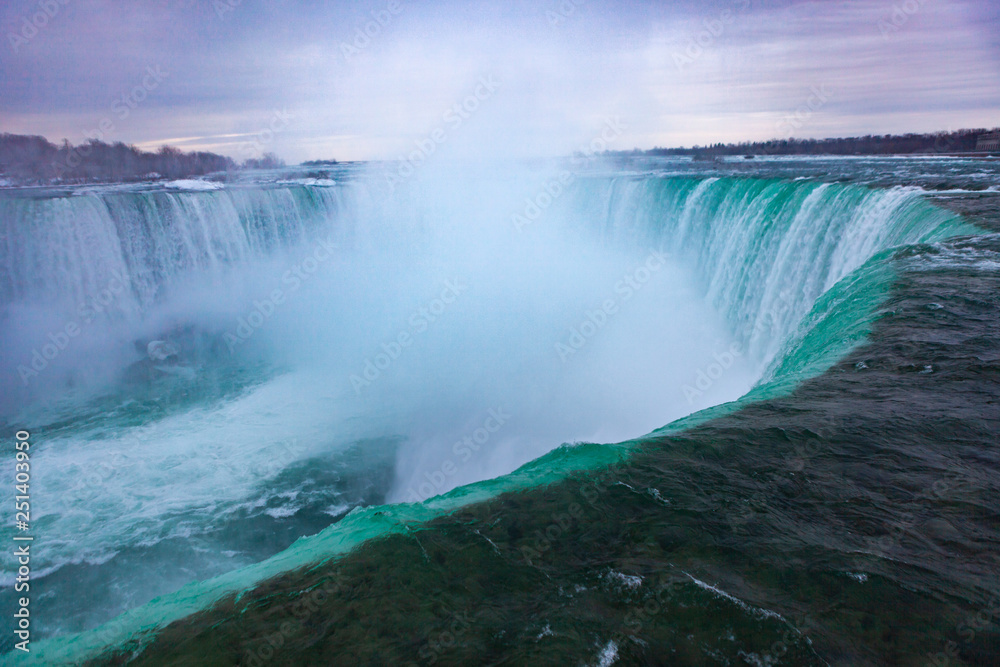 Niagara Falls CANADA - February 23, 2019: Winter frozen idyll at Horseshoe Falls, the Canadian side of Niagara Falls, view showing as well as the upper Niagara River Niagara Falls CANADA - February 23, 2019: Winter frozen idyll at Horseshoe Falls, the Canadian side of Niagara Falls, view showing as well as the upper Niagara River