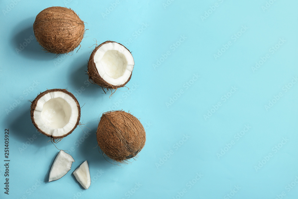 Flat lay composition with coconuts on color background. Space for text
