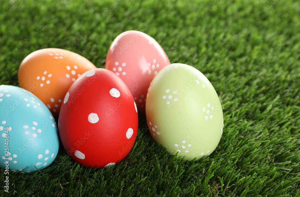 Colorful painted Easter eggs on green grass, closeup