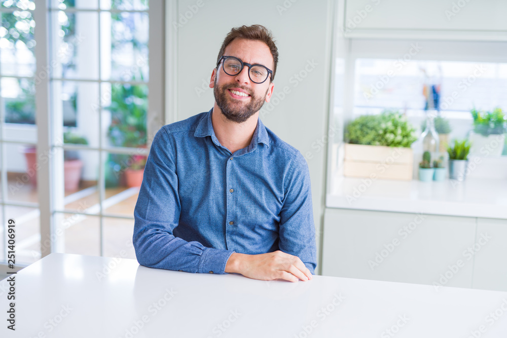 Handsome man wearing glasses and smiling relaxed at camera