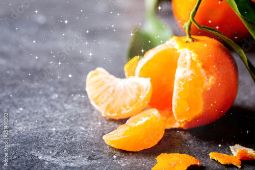 Fresh delicious mandarin, tangerine, clementine with green leaf on gray background. Ripe citrus fruits.Creative minimalistic food concept.Drawn Snowfall. Copy space for Text.