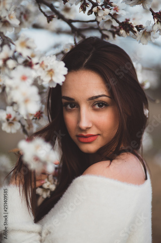Belle jeune femme au milieu des amandiers en fleurs