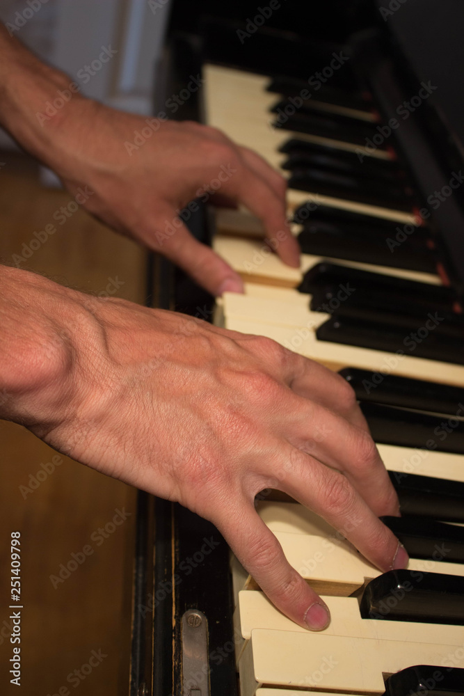 Fototapeta premium Close up of young boy hands, playing piano. vintage piano
