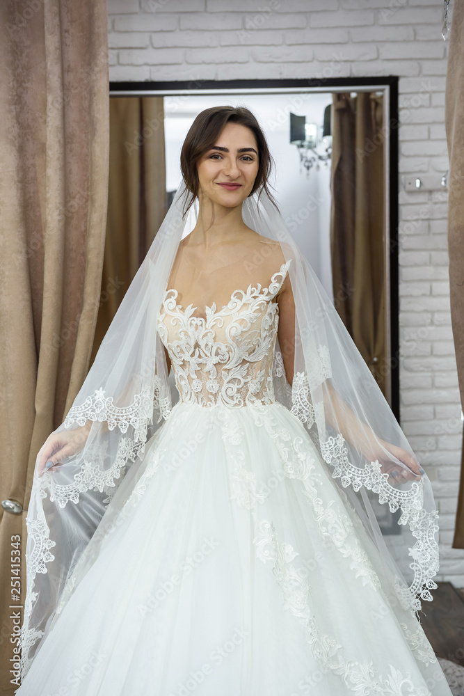 Smiling bride fitting dress in wedding salon Smiling bride fitting dress in wedding salon