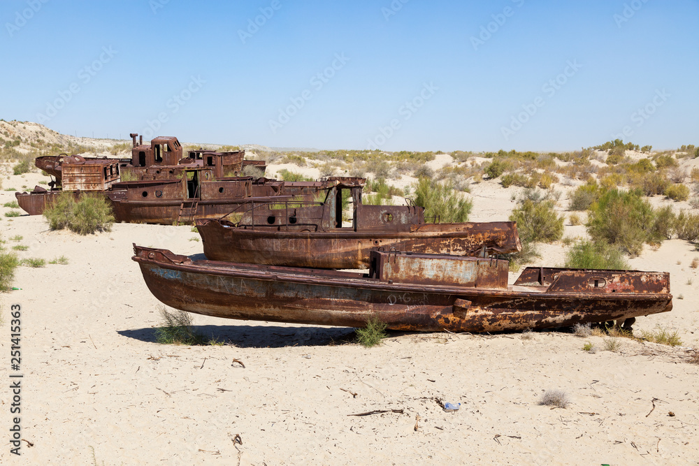 Rustic boats on a ship graveyards on a desert around Moynaq, Muynak or Moynoq - Aral sea or Aral lake - Uzbekistan in Central Asia