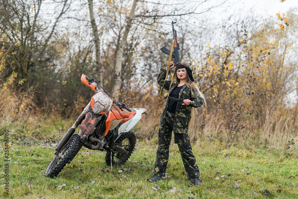 Young woman in camouflage clothes with gun Young woman in camouflage clothes with gun