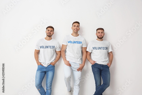 Group of young men in jeans on light background photo