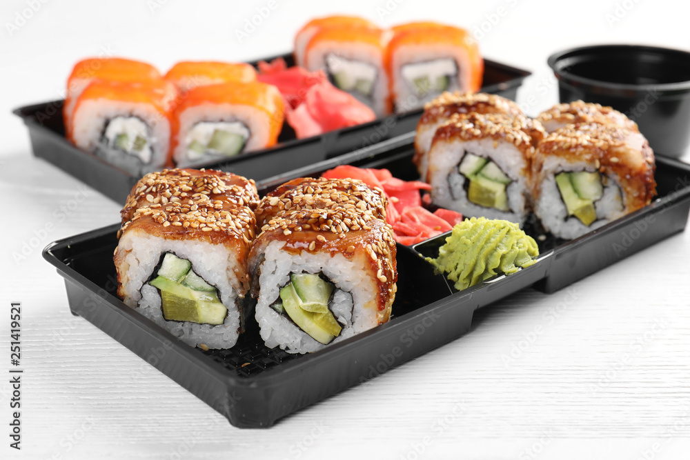 Boxes with tasty sushi rolls on white table. Food delivery Boxes with tasty sushi rolls on white table. Food delivery