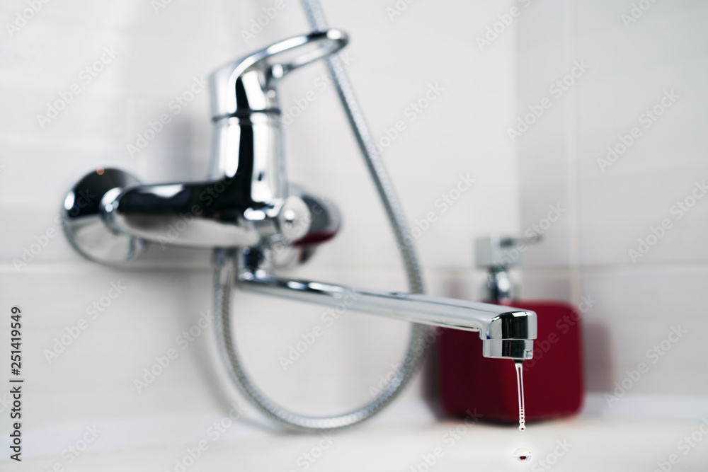 Clean water is dripping from the faucet in the bathroom. Selective focus. Clean water is dripping from the faucet in the bathroom. Selective focus.