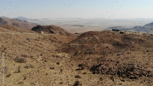 4x4 offroad vehicle driving up very steep Spreetshoogte Pass of central Namibia Khomas highland area close to Sossusvlei, Aerial drone shot photo