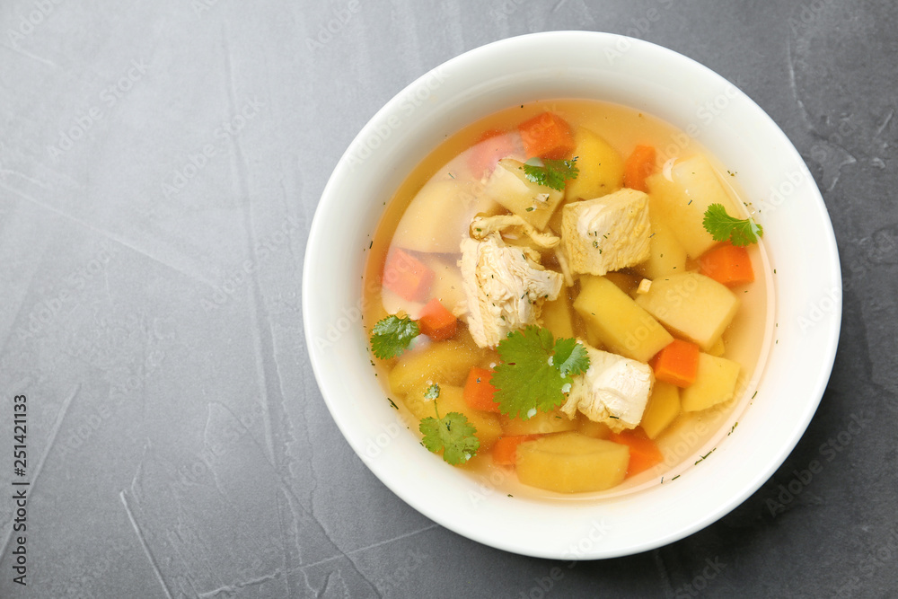 Homemade chicken soup in dish on grey background, top view with space for text Homemade chicken soup in dish on grey background, top view with space for text