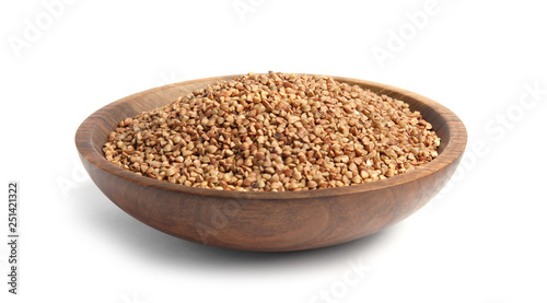 Bowl with uncooked buckwheat on white background