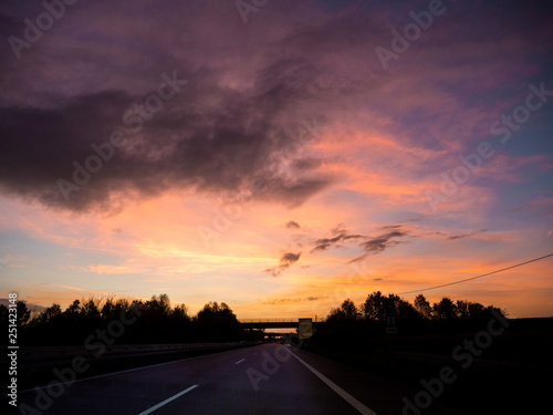 Driving on german autobahn on a beautiful sunset with magenta purple and ornage tones