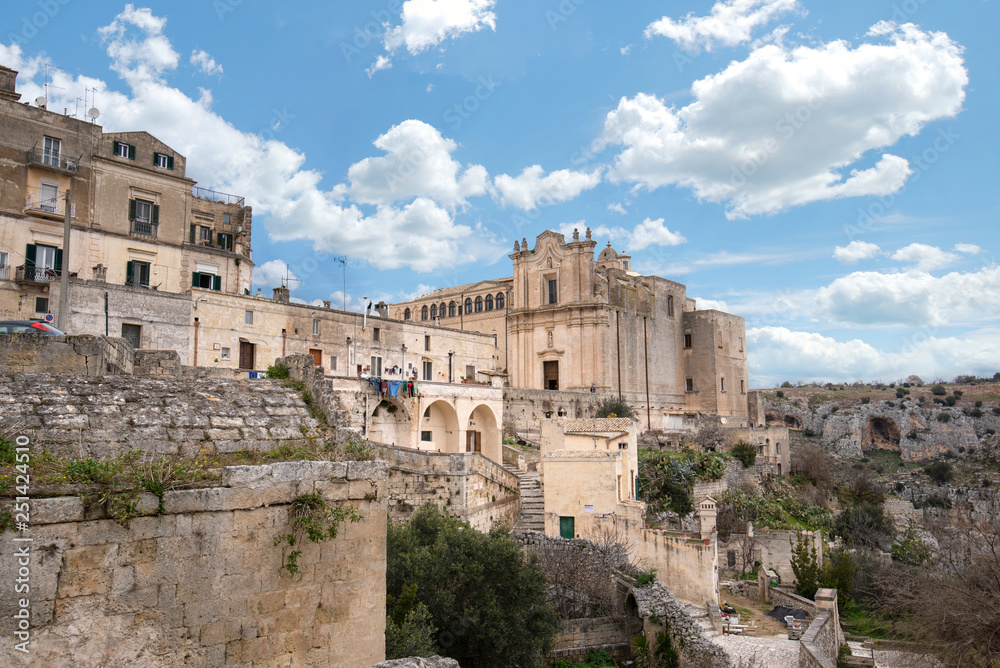 The Convent of Saint Agostino sitting on a steep cliff overlooking a deep canyon ravine filled with prehistoric sassi caves in Matera, Italy. An Unesco World Heritage site. Capital culture 2019