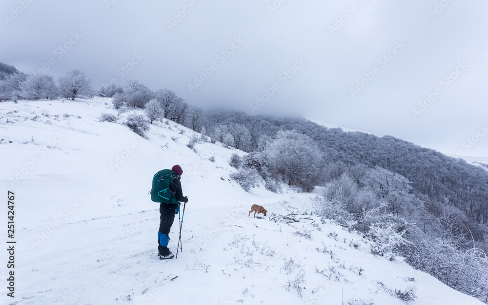 Young girl trekking through deep snow on a cold day in the mountains of Romania