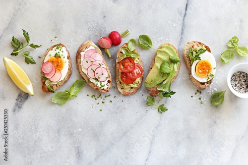 Breakfast sandwich bread with avocado, egg, radishes and tomatoes. Bruschetta or healthy snack ideas