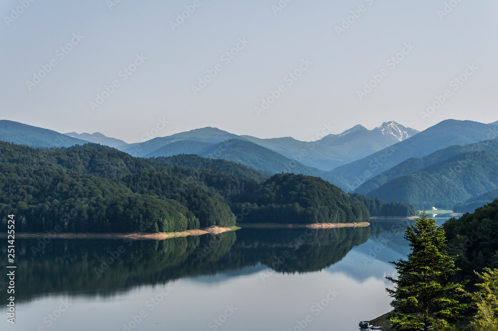 Fantastic panorama of mountain lake with overcast sky of Vidraru Lake. Vidraru Dam, Romania. Carpathian Mountains, Fagaras ridge