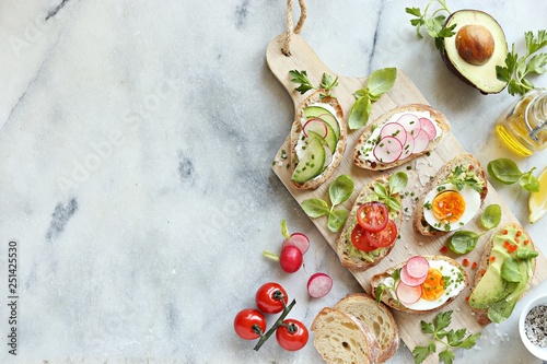 Breakfast sandwich bread with avocado, egg, radishes and tomatoes. Bruschetta or healthy snack ideas