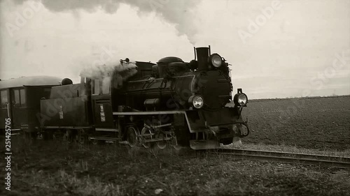Old passangers train running on the tracks. Retro locomotive with steam engine loopable black and white footage. photo