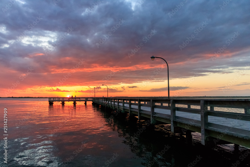 Beautiful sunset over fishing piers on Long Island New York. Colorful orange and pink sky - golden light