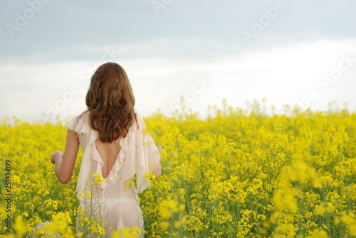 A young tall woman with a long hair at the yellow field © Siuzanna