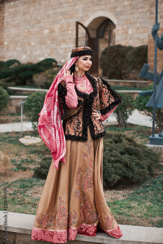 Beautiful woman wearing oriental national clothes posing outdoor