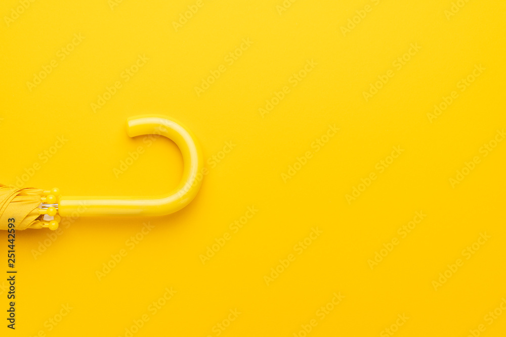 folded umbrella on the yellow background with copy space folded umbrella on the yellow background with copy space