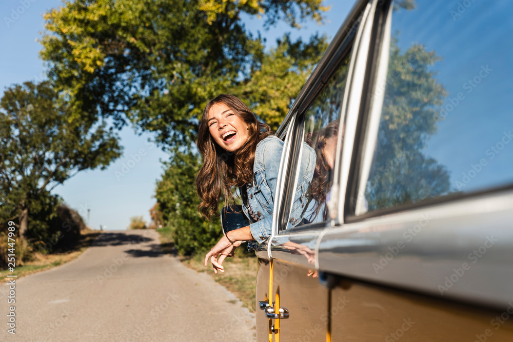 Pretty woman on a road trip with her camper, looking out of car window ...