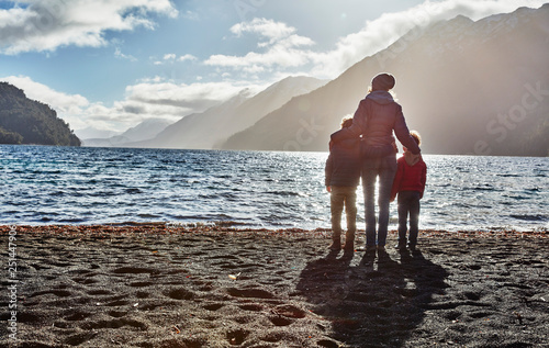 Argentina, Patagonia, Lago Nahuel Huapi, woman with two sons standing at the shore overlooking the lake photo