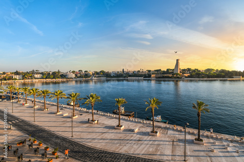 Quadro su tela The Italian Sailor Monument, promenade and bay as the sun sets in the seaside port city of Brindisi Italy in the Southern region of Puglia