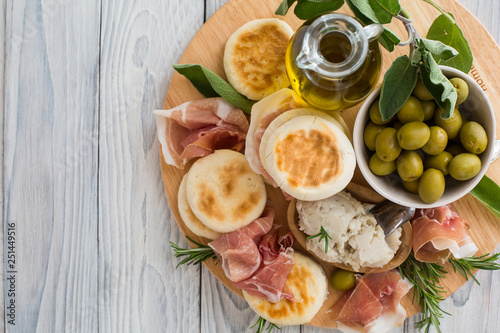 Crescentina modenese or tigelle ,  round breads from the Apennines, Modena area of Emilia-Romagna, Northern Italy, with cunza, a spread made from pork lard and flavoured with garlic and rosemary photo