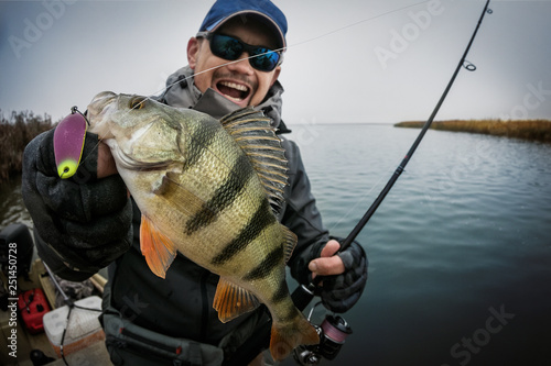 Fototapeta Happy angler with perch fishing trophy.
