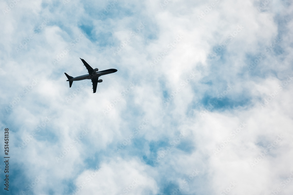 Bottom view of airplane silhouette, flying in the sky.