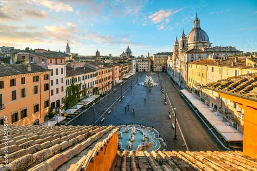 Early morning view from a terrace overlooking the Piazza Navona as the sunlight lights the dome on the St. Agnes Cathedral in Rome, Italy photo