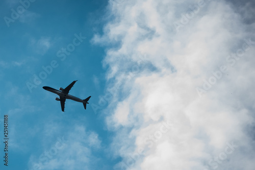 Bottom view of airplane silhouette, flying in the sky.