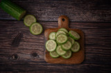 Fresh sliced cucumbers on an old wooden table. Top view, healthy food concept