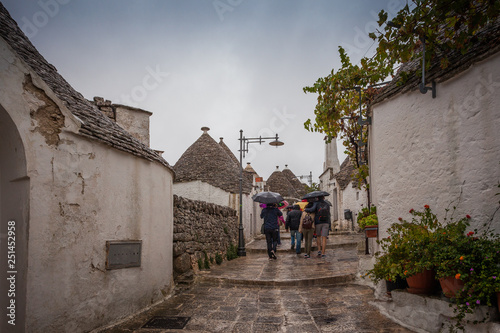 Tourists in the rain as they visit the streets of the village