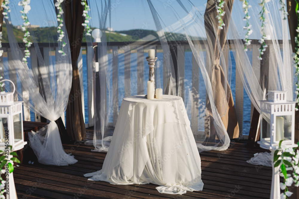 Table with a candlestick in the gazebo at the pier Table with a candlestick in the gazebo at the pier